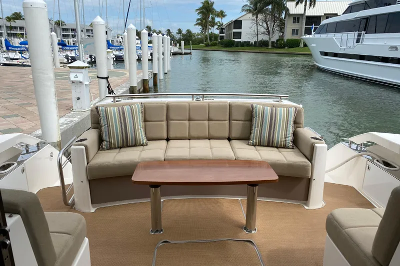 Rosalinda Yacht Photos Pics 2015 Tiara Yachts C44 Coupe interior with beige seating and wooden table, docked at marina.
