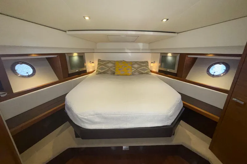 Rosalinda Yacht Photos Pics Luxurious bedroom interior of 2015 Tiara Yachts C44 Coupe with elegant bedding and porthole windows.