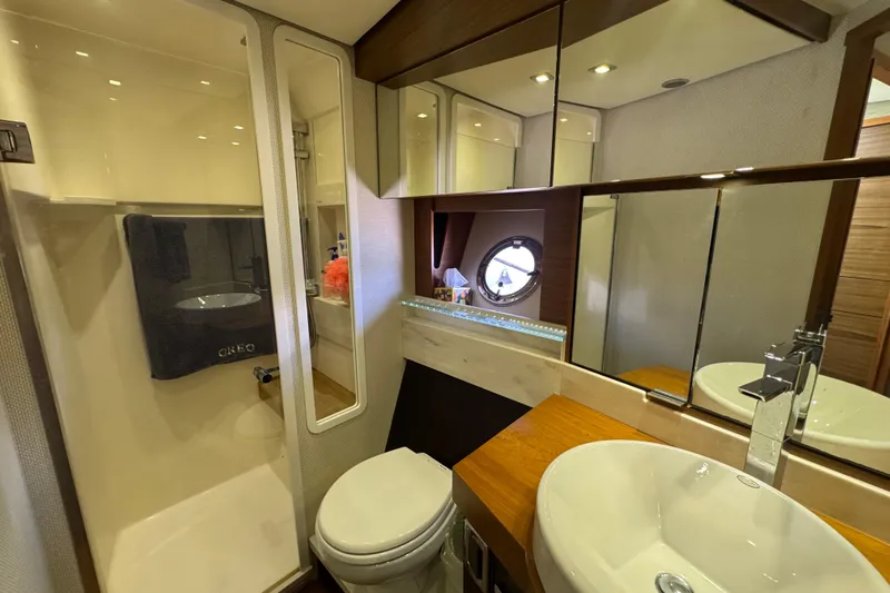 Rosalinda Yacht Photos Pics Luxurious bathroom in 2015 Tiara Yachts C44 Coupe, featuring modern fixtures and porthole window.