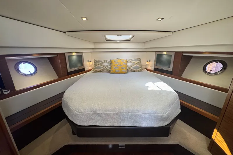 Rosalinda Yacht Photos Pics Luxurious 2015 Tiara Yachts C44 Coupe cabin with elegant bedding and porthole windows.