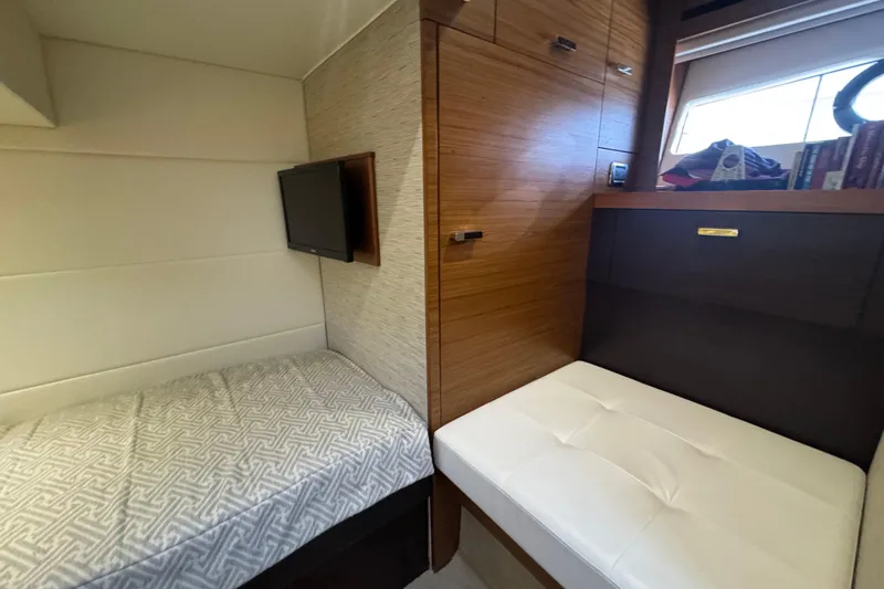 Rosalinda Yacht Photos Pics Interior of 2015 Tiara Yachts C44 Coupe with bed, TV, and seating area.