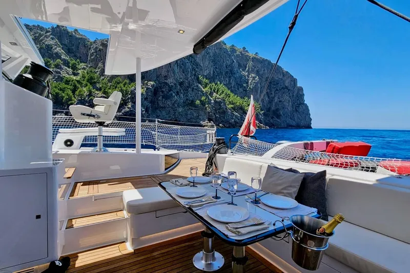  Yacht Photos Pics Luxurious 2016 HH Catamarans HH66 yacht with elegant dining setup, scenic ocean view.