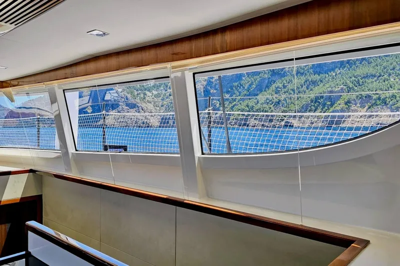  Yacht Photos Pics Interior view from 2016 HH Catamarans HH66, showcasing scenic ocean and coastline through large windows.