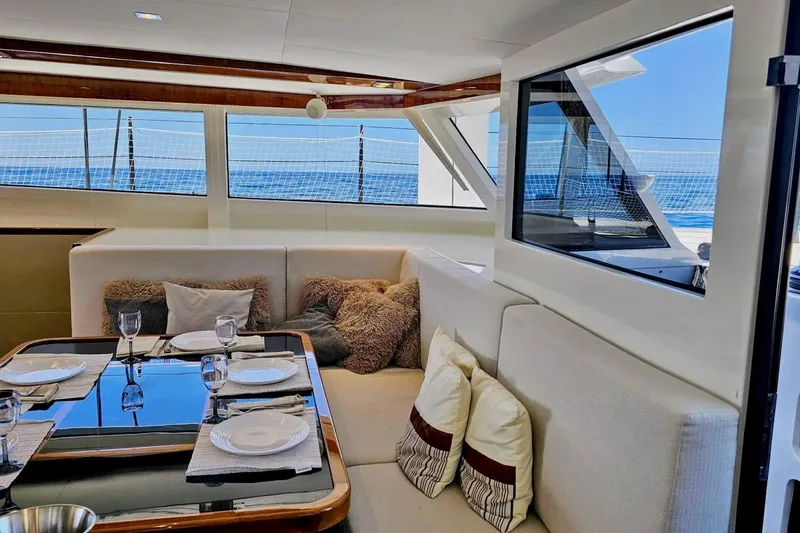  Yacht Photos Pics Luxurious interior of 2016 HH Catamarans HH66 with elegant dining setup and ocean view.