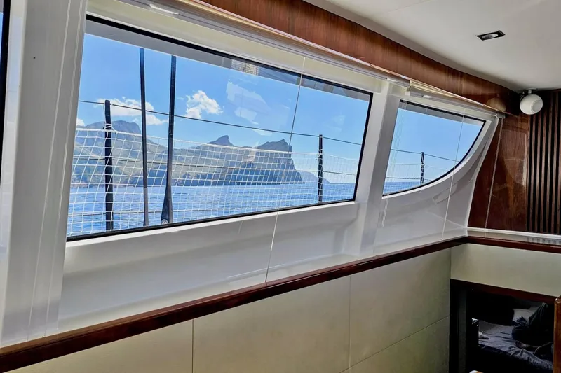  Yacht Photos Pics Interior view from 2016 HH Catamarans HH66, showcasing ocean and mountain scenery through large windows.