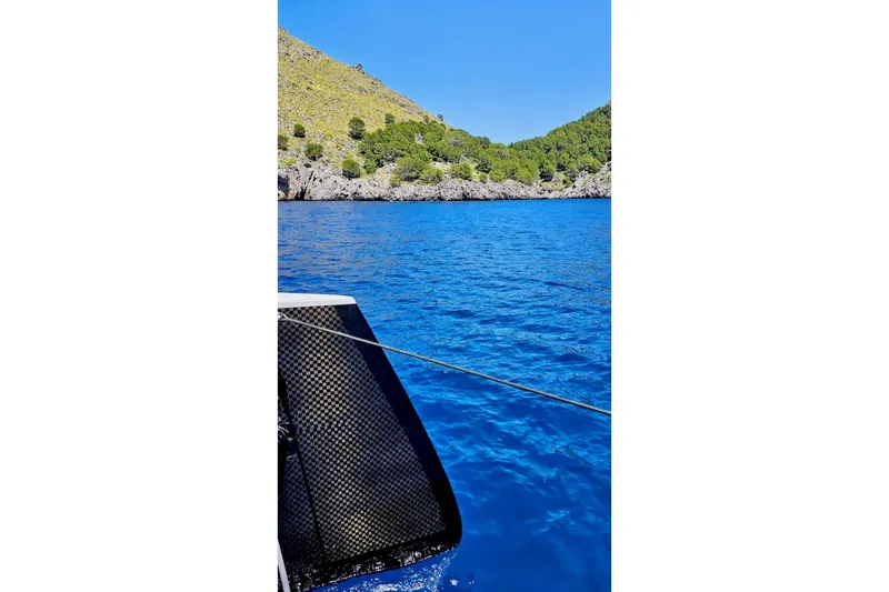  Yacht Photos Pics 2016 HH Catamarans HH66 sailing in clear blue waters near rocky coastline.