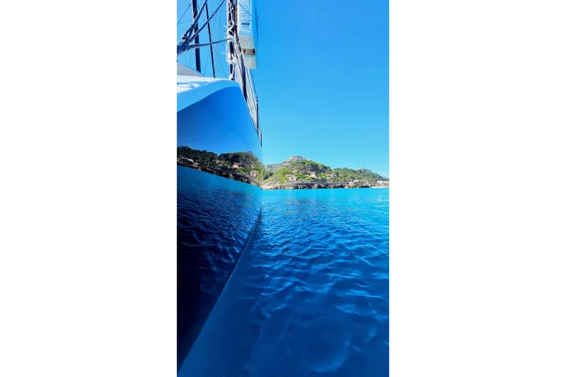  Yacht Photos Pics 2016 HH Catamarans HH66 sailing on clear blue waters near a scenic coastline.