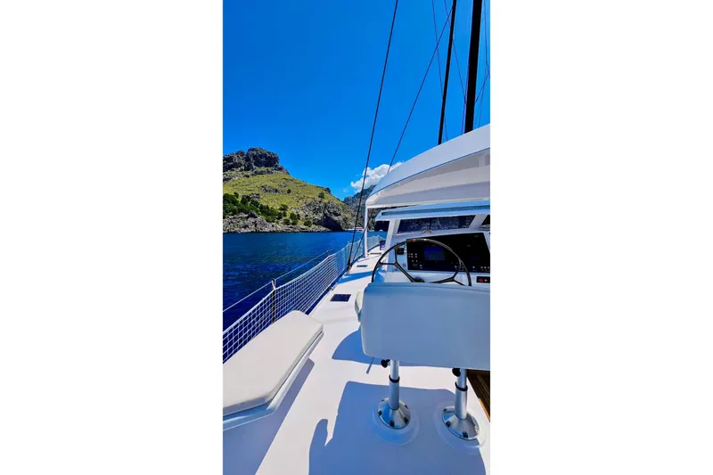  Yacht Photos Pics 2016 HH Catamarans HH66 sailing in clear blue waters near rocky coastline.