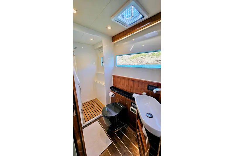  Yacht Photos Pics Luxurious bathroom interior of 2016 HH Catamarans HH66, featuring modern fixtures and wood accents.