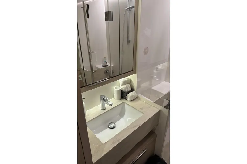 Va Bene Yacht Photos Pics Modern bathroom sink in 2022 Lagoon 55 yacht, featuring sleek design and mirrored cabinet.
