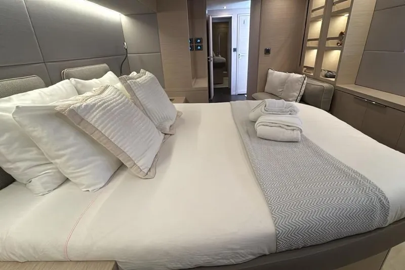 Va Bene Yacht Photos Pics Luxurious bedroom interior of 2022 Lagoon 55 yacht with elegant bedding and ambient lighting.