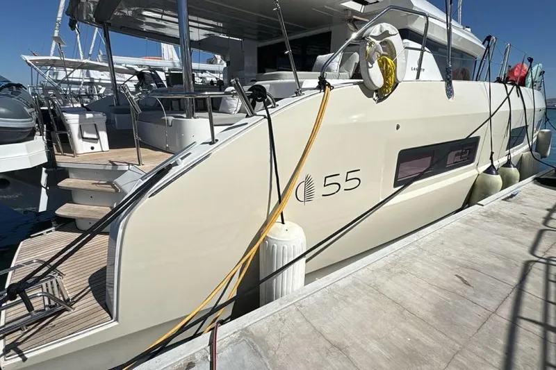 Va Bene Yacht Photos Pics 2022 Lagoon 55 yacht docked at marina, showcasing sleek design and modern features.