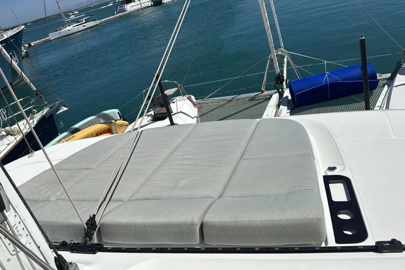 Va Bene Yacht Photos Pics 2022 Lagoon 55 yacht with cushioned deck, docked at marina.