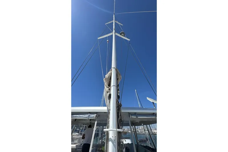 Va Bene Yacht Photos Pics Mast of 2022 Lagoon 55 sailboat against clear blue sky.