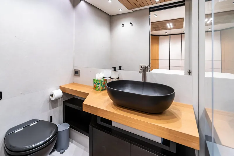 Matzu II Yacht Photos Pics Modern bathroom on 2023 Wally WHY 150 yacht with sleek black fixtures and wooden accents.
