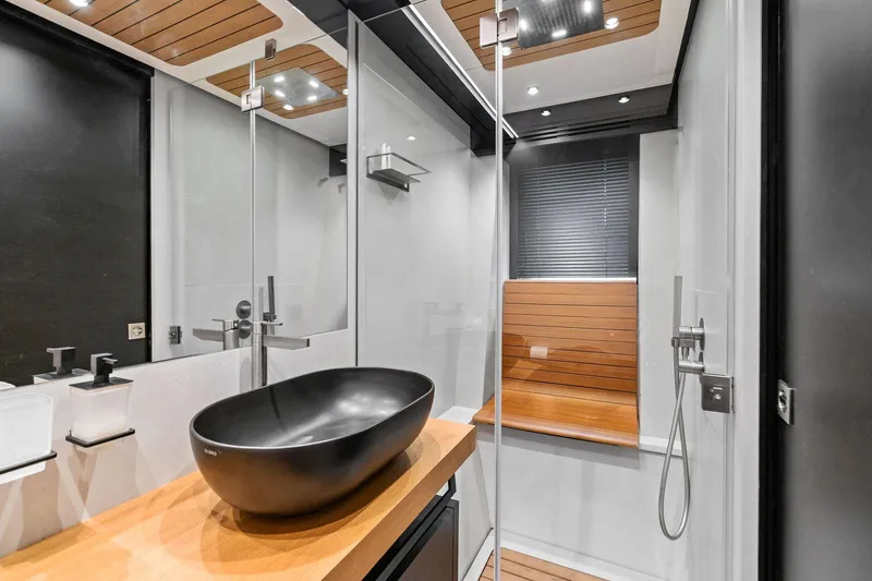 Matzu II Yacht Photos Pics Modern bathroom in 2023 Wally WHY 150 yacht with sleek black sink and wooden accents.