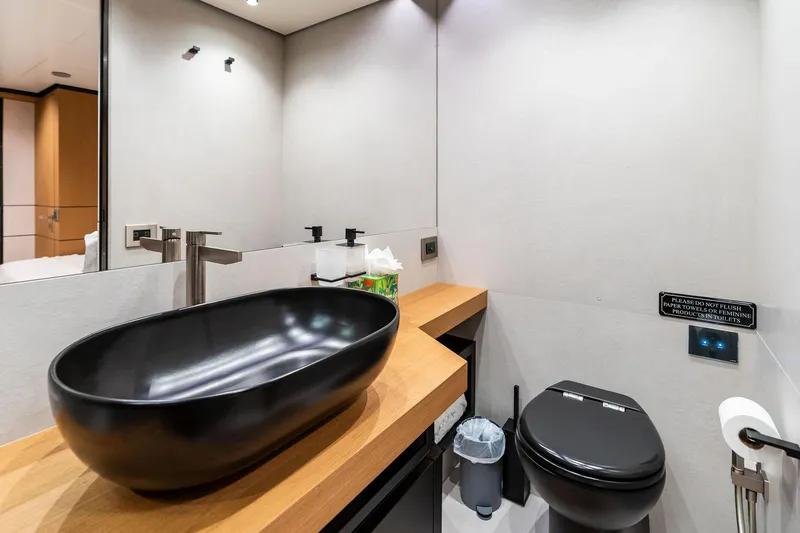 Matzu II Yacht Photos Pics Modern bathroom on 2023 Wally WHY 150 yacht with sleek black fixtures and wooden countertop.