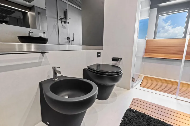 Matzu II Yacht Photos Pics Modern bathroom on 2023 Wally WHY 150 yacht with sleek black fixtures and wooden accents.