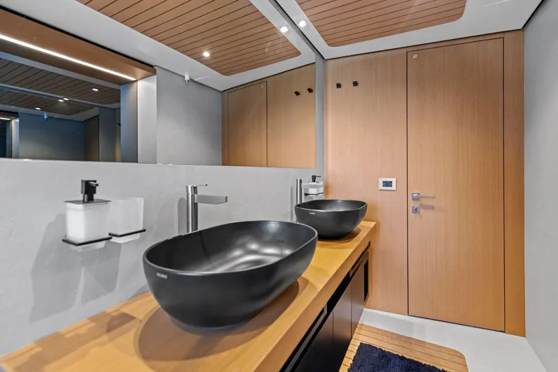 Matzu II Yacht Photos Pics Modern bathroom interior on 2023 Wally WHY 150 yacht with sleek black sinks and wooden accents.