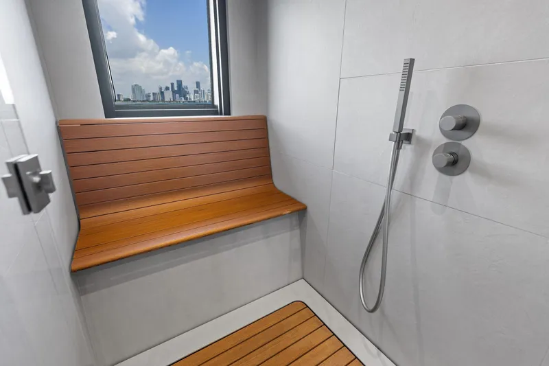 Matzu II Yacht Photos Pics Modern shower with wooden bench and city view on Wally WHY 150 yacht, 2023 model.