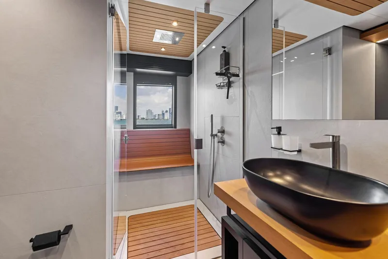 Matzu II Yacht Photos Pics Modern yacht bathroom with sleek black sink, wooden accents, and city view. Wally WHY 150, 2023.