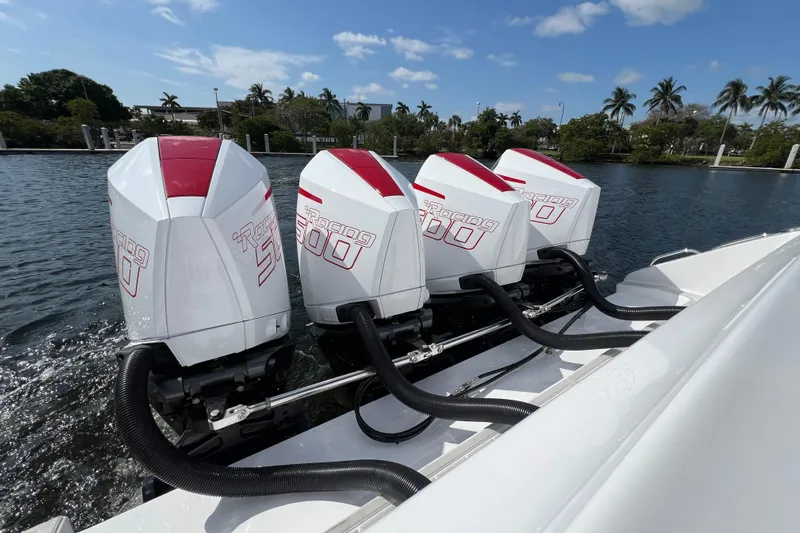  Yacht Photos Pics Four powerful outboard engines on a 2025 Cigarette 41 Nighthawk boat, docked by palm trees.