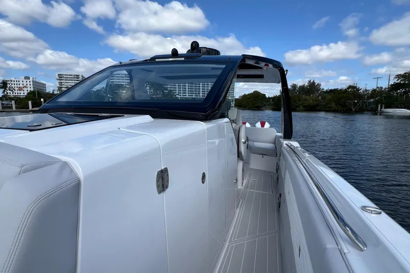  Yacht Photos Pics 2025 Cigarette 41 Nighthawk boat on water, sleek design, clear sky, modern architecture.