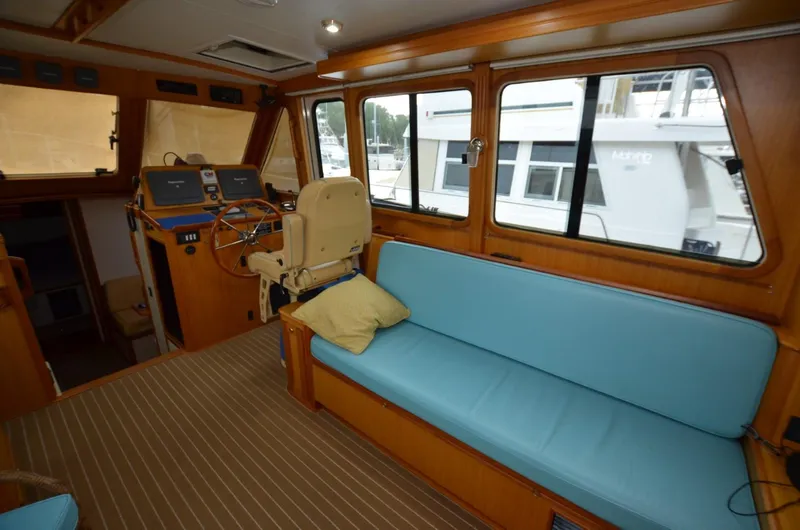 O Henry Yacht Photos Pics 2006 Legacy Yachts Sedan interior with blue seating, helm station, and large windows.