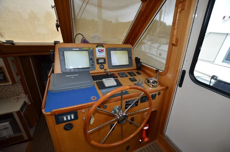 O Henry Yacht Photos Pics 2006 Legacy Yachts Sedan helm with navigation equipment and wooden steering wheel.