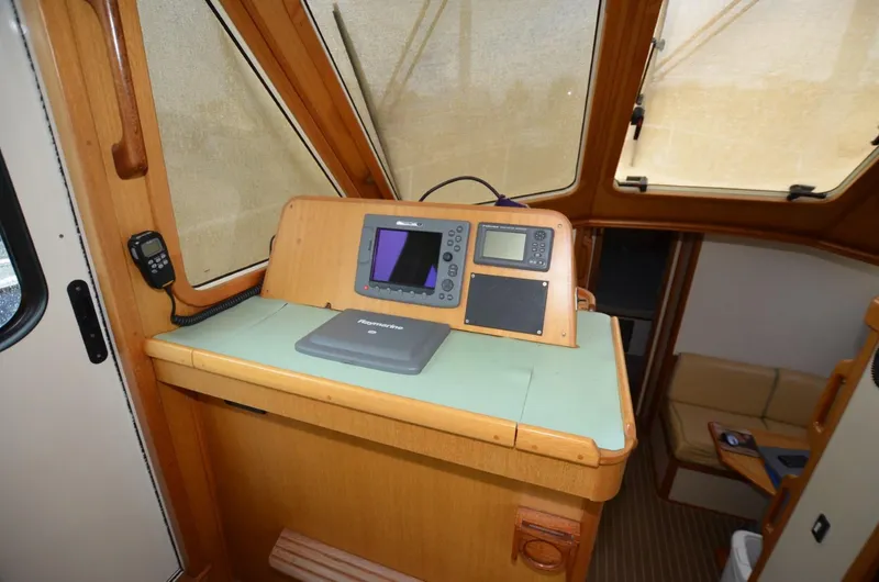 O Henry Yacht Photos Pics 2006 Legacy Yachts Sedan interior helm with navigation equipment and wooden finish.