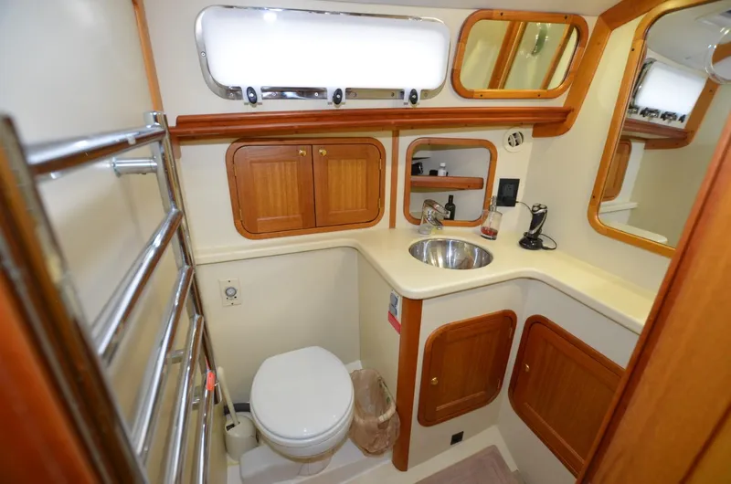 O Henry Yacht Photos Pics 2006 Legacy Yachts Sedan bathroom with wooden cabinets, sink, and toilet.