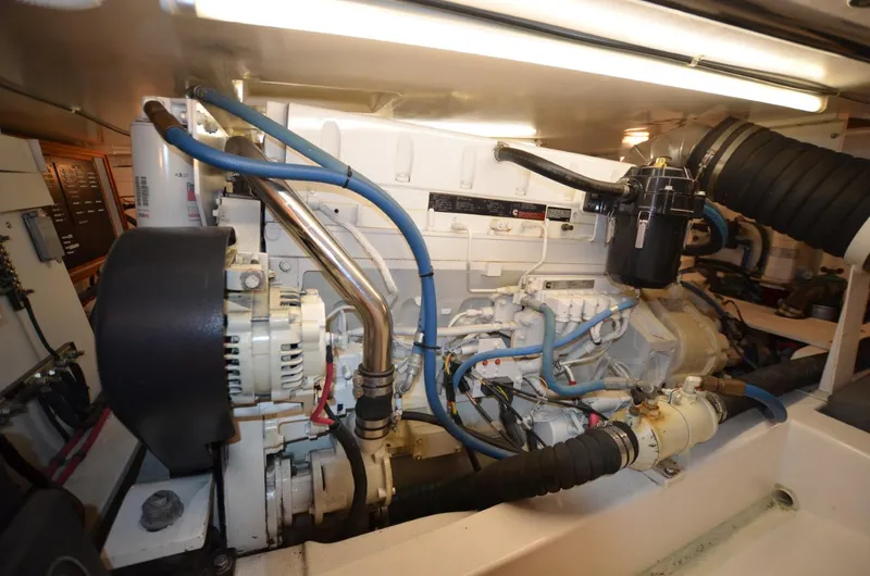 O Henry Yacht Photos Pics Engine room of a 2006 Legacy Yachts Sedan, showcasing mechanical components and blue hoses.