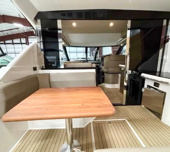 B Seaductive Yacht Photos Pics Interior of 2014 Regal 42 Sport Coupe with wooden table and seating area.