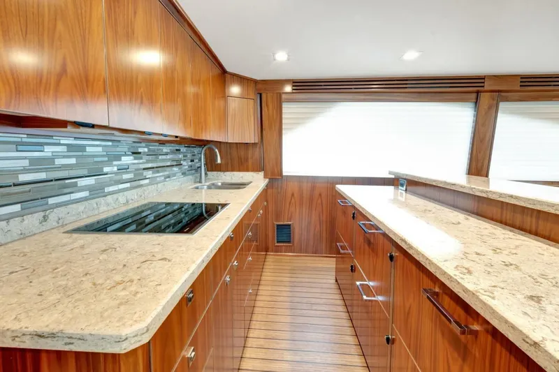 Desparado Yacht Photos Pics Luxurious kitchen interior of 2019 Viking 68 Convertible yacht with wood cabinetry and modern appliances.