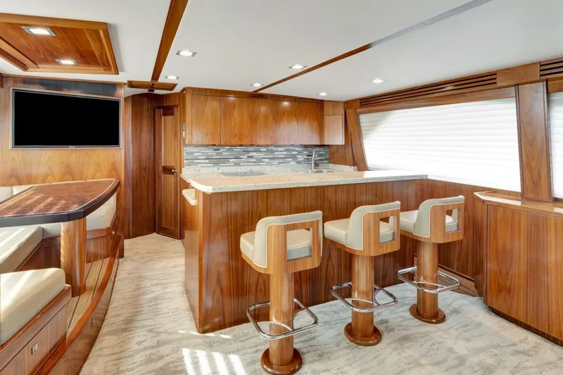 Desparado Yacht Photos Pics Luxurious interior of 2019 Viking 68 Convertible yacht with wooden finishes and bar seating.
