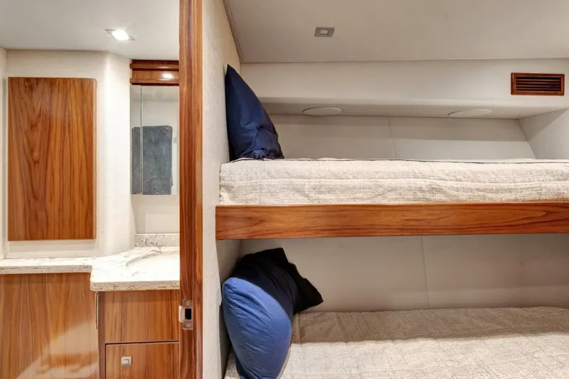 Desparado Yacht Photos Pics Interior of 2019 Viking 68 Convertible yacht with cozy bunk beds and wooden cabinetry.
