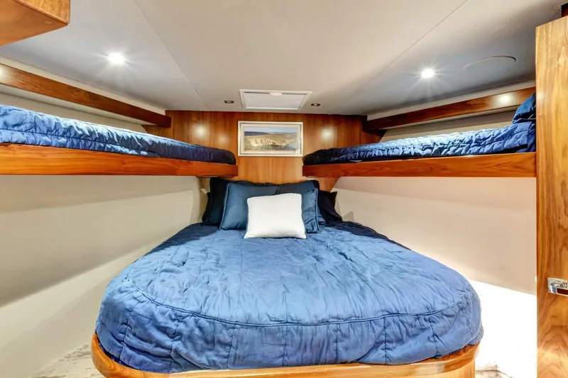 Desparado Yacht Photos Pics Luxurious cabin interior of 2019 Viking 68 Convertible yacht with blue bedding and wooden accents.
