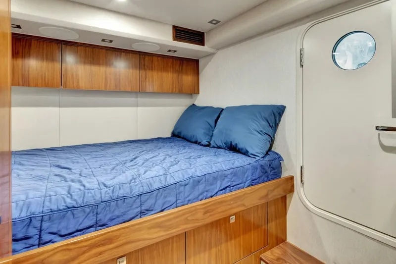 Desparado Yacht Photos Pics 2019 Viking 68 Convertible yacht cabin with blue bedding and wooden storage.