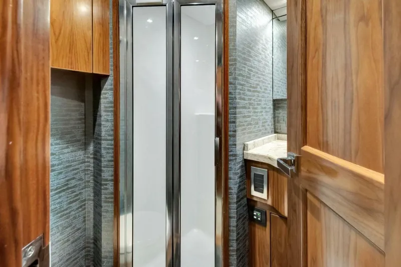 Desparado Yacht Photos Pics Luxurious bathroom interior of 2019 Viking 68 Convertible yacht with wood accents and modern fixtures.