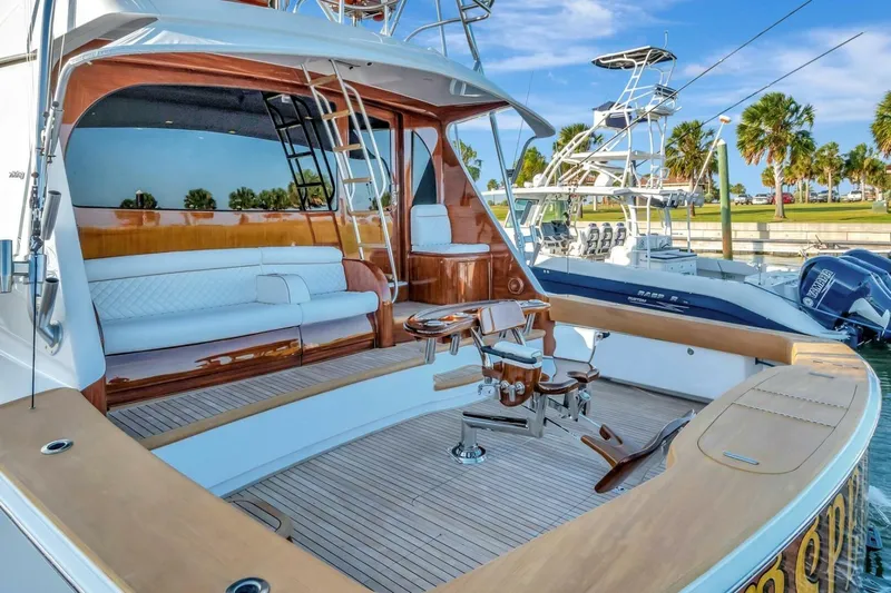 Desparado Yacht Photos Pics 2019 Viking 68 Convertible yacht with luxurious deck and seating area, docked at marina.