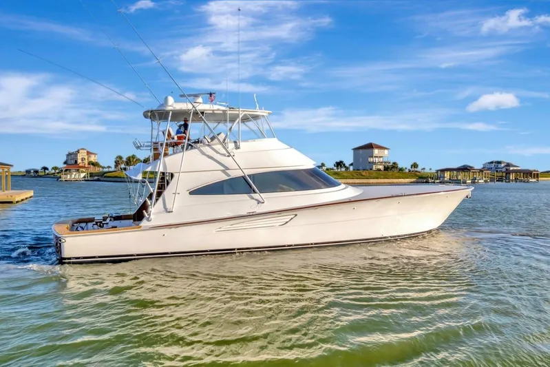 Desparado Yacht Photos Pics 2019 Viking 68 Convertible yacht cruising on a sunny day near waterfront homes.