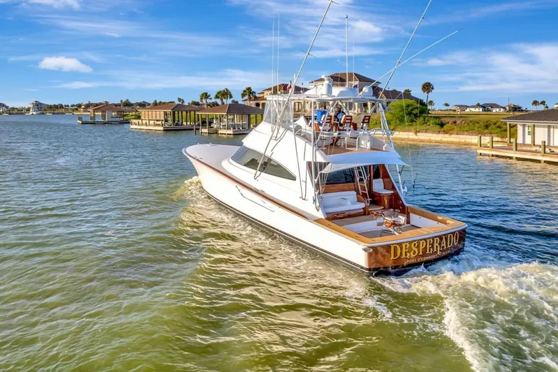 Desparado Yacht Photos Pics 2019 Viking 68 Convertible yacht cruising in a scenic coastal area.