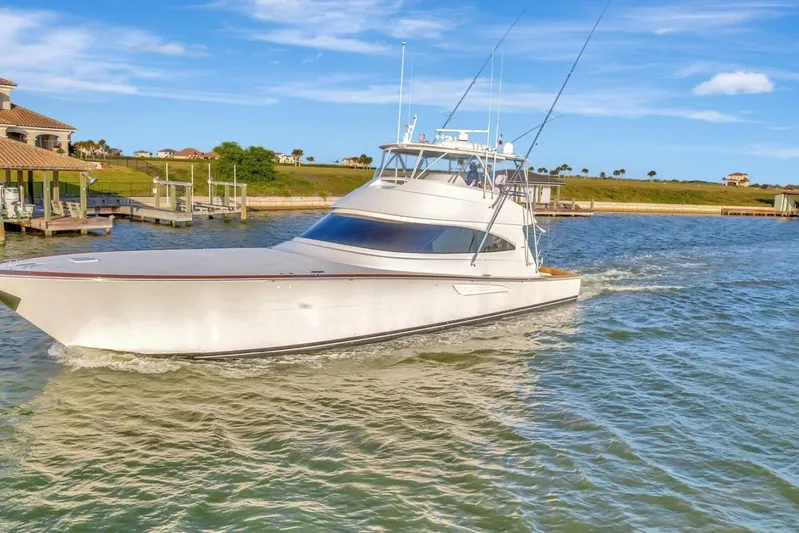 Desparado Yacht Photos Pics 2019 Viking 68 Convertible yacht cruising on a sunny day near a dock.