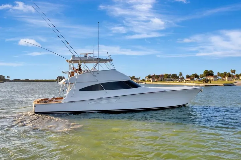 Desparado Yacht Photos Pics 2019 Viking 68 Convertible yacht cruising on a sunny day near the shore.