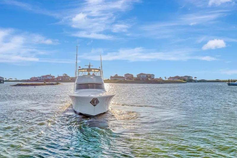 Desparado Yacht Photos Pics 2019 Viking 68 Convertible yacht cruising on a sunny day near coastal homes.