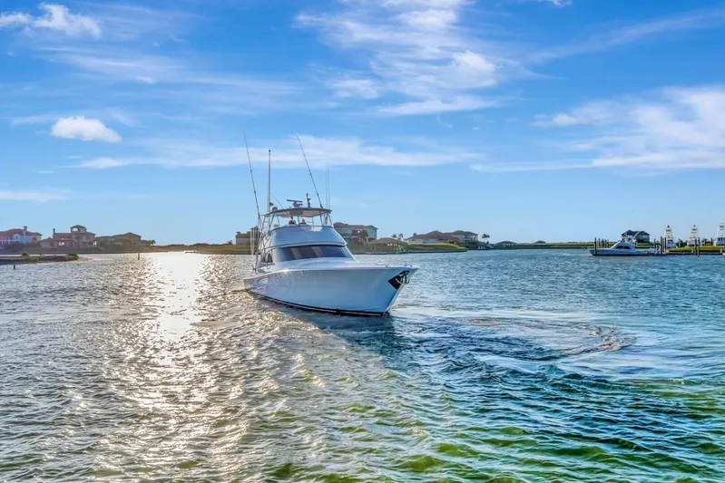Desparado Yacht Photos Pics 2019 Viking 68 Convertible yacht cruising on a sunny day in a scenic harbor.
