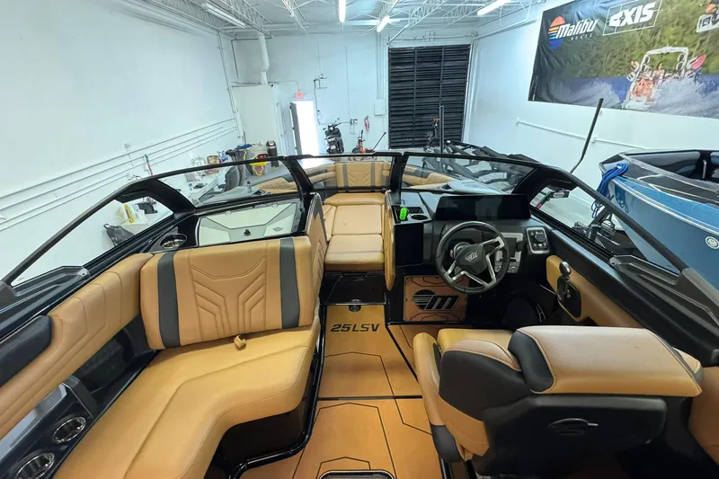  Yacht Photos Pics 2026 Malibu Wakesetter 25 LSV interior with tan seating and modern dashboard.