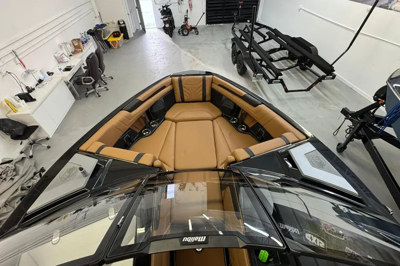  Yacht Photos Pics 2026 Malibu Wakesetter 25 LSV interior with tan seating in a garage setting.