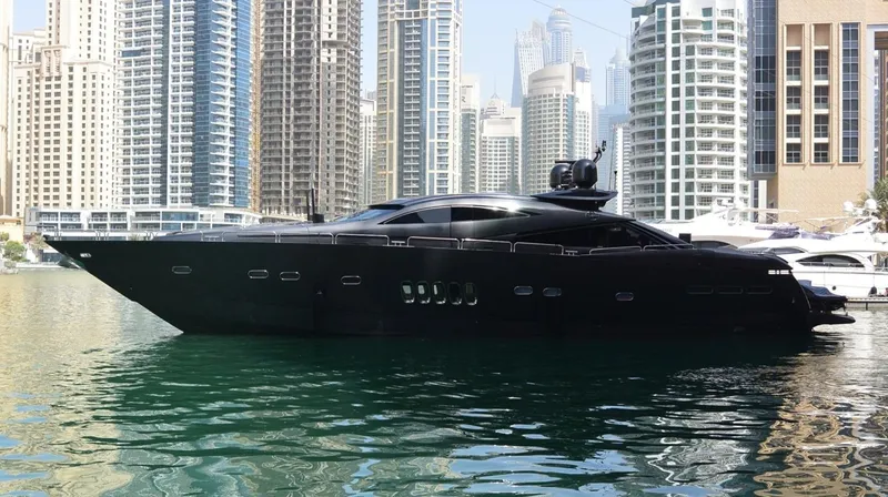  Yacht Photos Pics 2004 Sunseeker Predator 95 yacht docked in a marina with skyscrapers in the background.