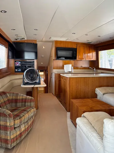 Audrey IV Yacht Photos Pics Interior of 2002 Hatteras 50 Convertible yacht with wood cabinetry and cozy seating area.
